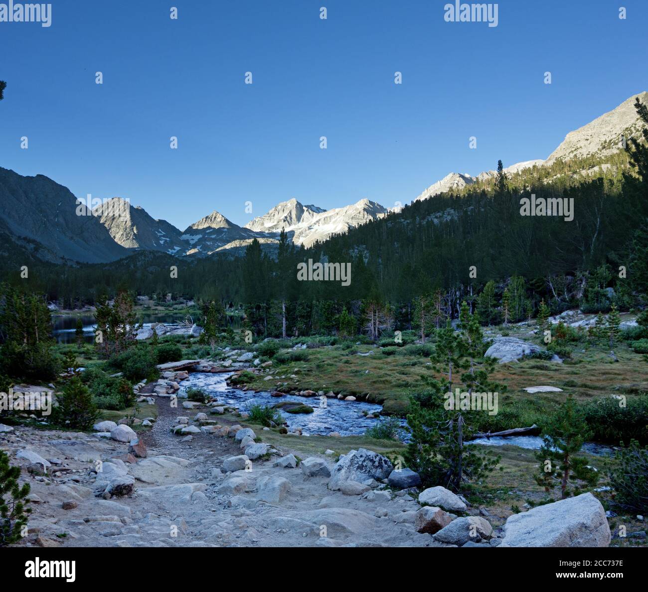 Vue sur la vallée de Little Lakes en direction de Bear Creek Spire le matin avec le sentier et un pont sur un flux Banque D'Images