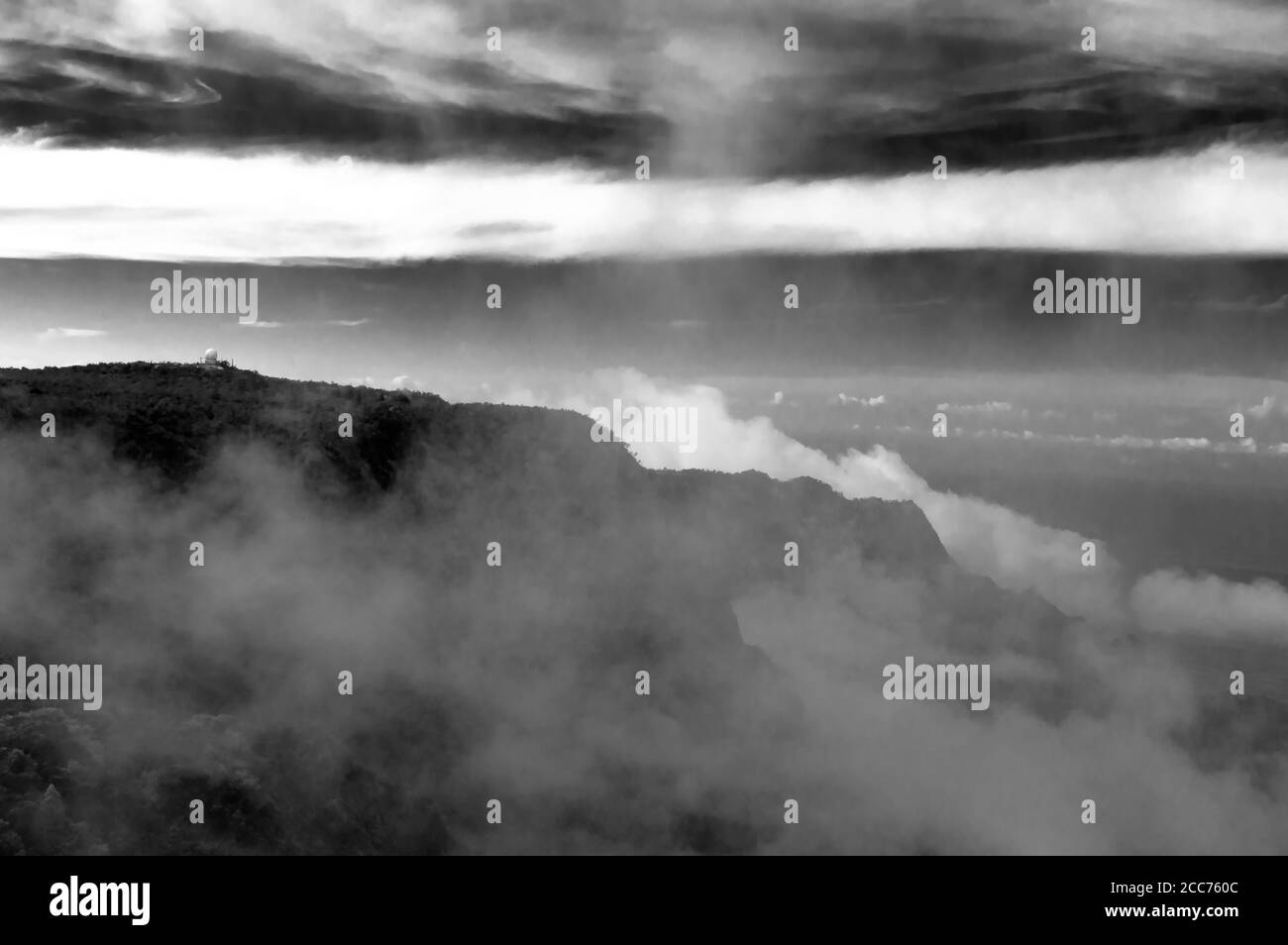 Observatoire d'Hawaï au bord d'une falaise, entouré de brouillard et de nuages. Banque D'Images