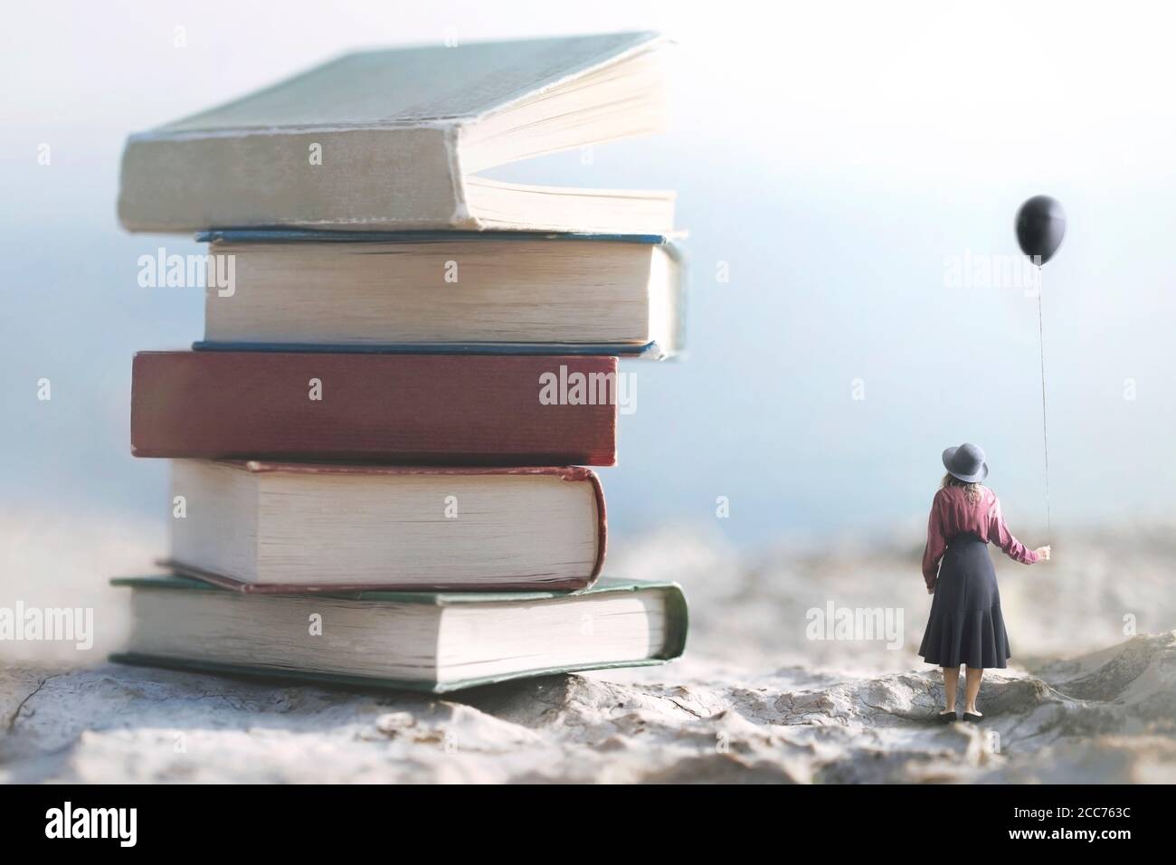femme avec ballon regarde émerveillé à une montagne de géant livres Banque D'Images