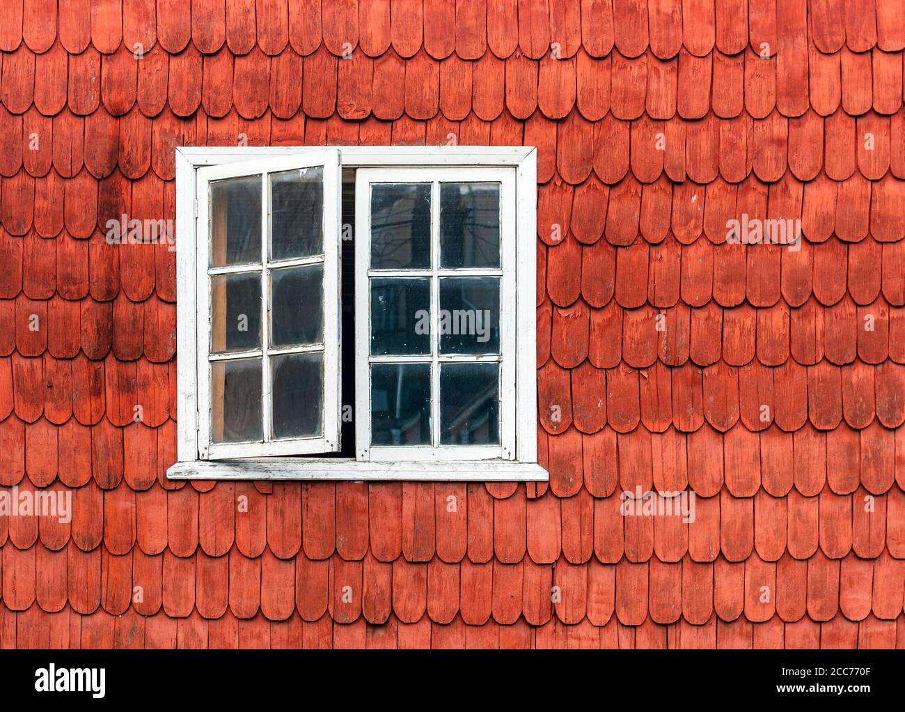 Construction traditionnelle de logements dans le quartier des lacs du Chili en bois de mélèze avec une façade et une fenêtre ouverte, Castro, île Chiloe, Chili. Banque D'Images