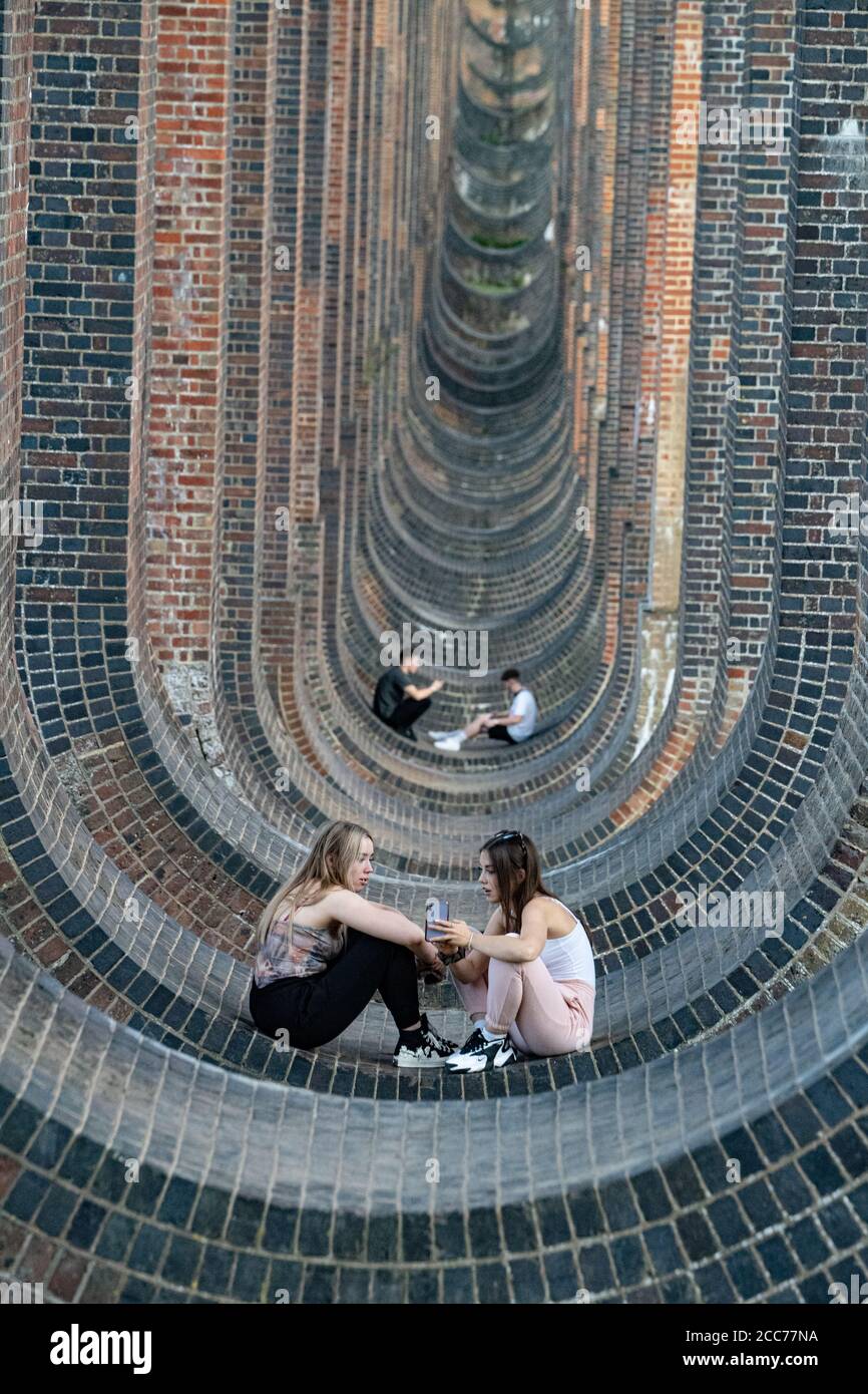 Jeunes sous le Viaduc de la vallée de l'Ouse (Viaduc de Balcombe) transportant la ligne de chemin de fer de Londres à Brighton au-dessus de la rivière Ouse à Sussex, au Royaume-Uni Banque D'Images
