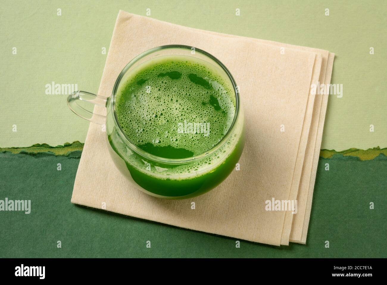 une tasse de verre de jus de concombre frais fait maison sur une serviette de papier coloré résumé, concept de saine alimentation Banque D'Images