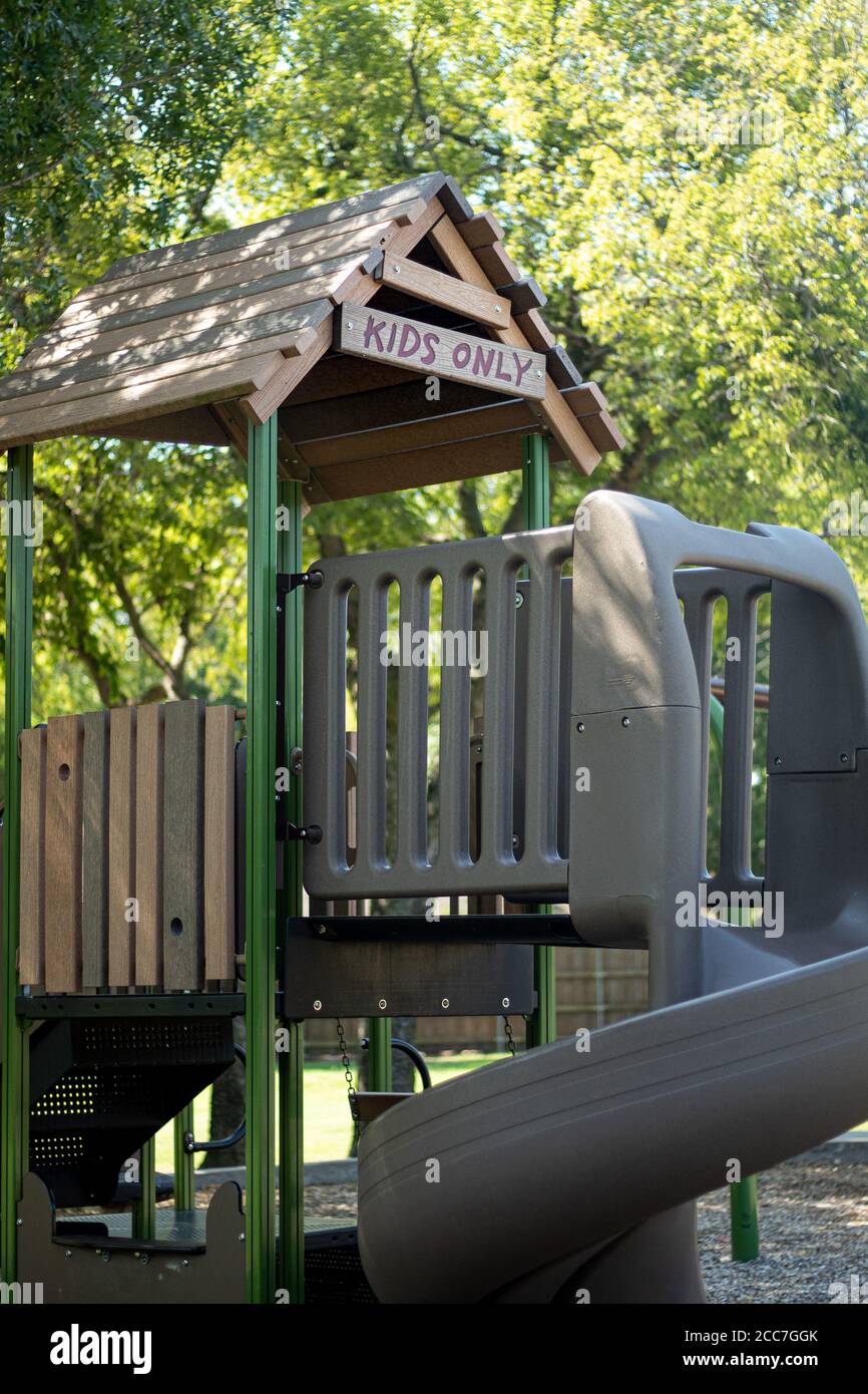 Enfants seulement Inscrivez-vous sur l'équipement de terrain de jeu de banlieue dans le parc communautaire Banque D'Images
