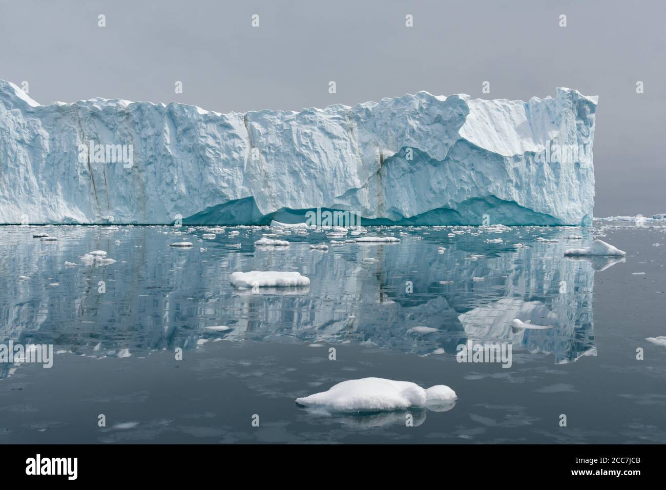 Un énorme iceberg tabulaire et sa réflexion dans l'eau calme et vivivivivivile de l'Antarctique. Banque D'Images