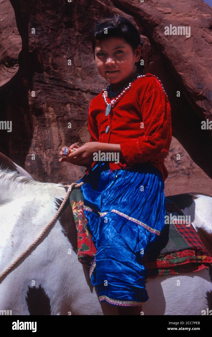 Jeune fille indienne Navaho sur son cheval, en vêtements traditionnels. Monument Valley, Arizona, États-Unis. Photographié août 1963. Banque D'Images