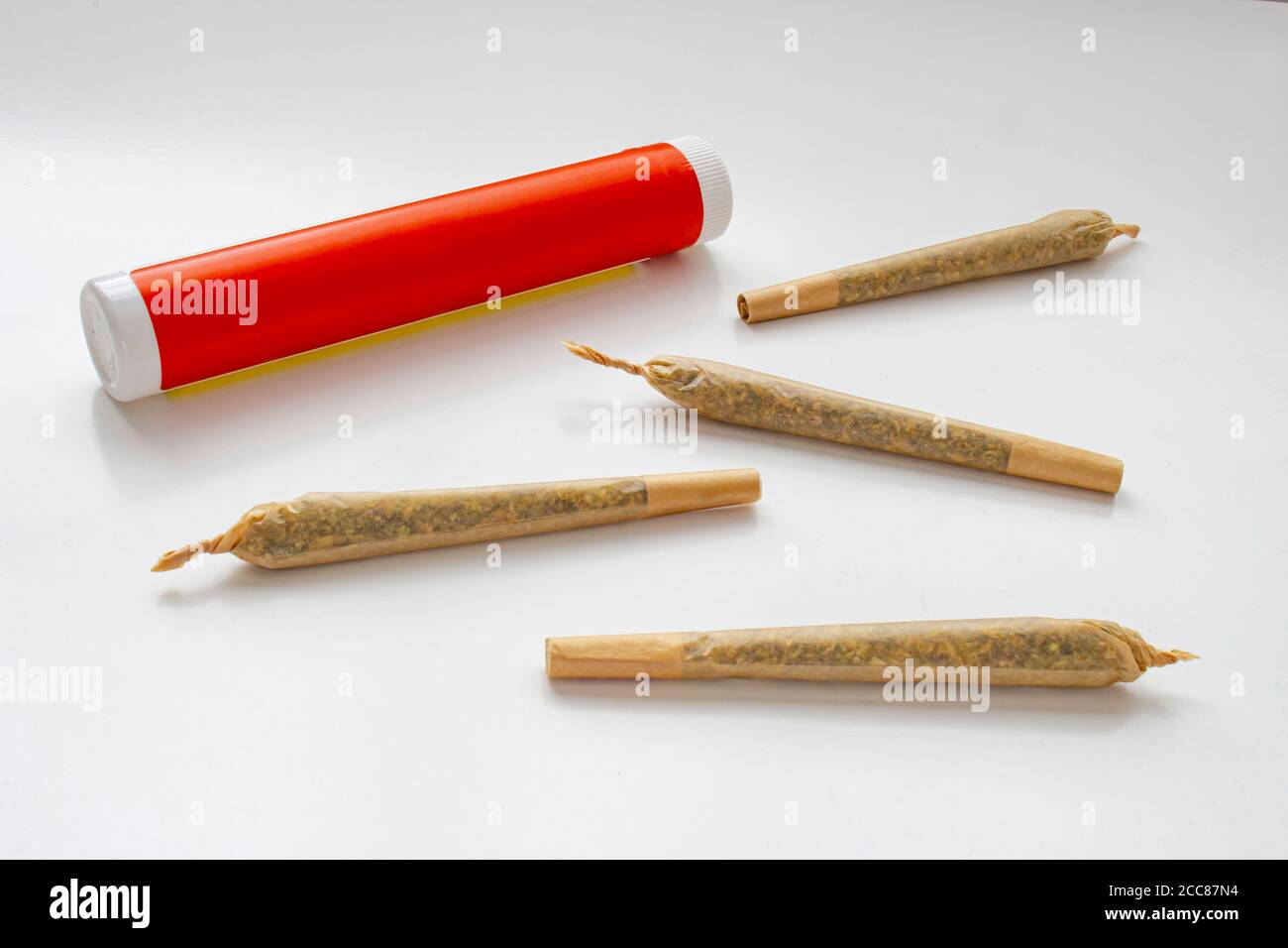 Un emballage en plastique blanc et rouge de cannabis pour les Prerolls Ou des articulations avec pré-rouleaux de cannabis joints autour et un sur un arrière-plan blanc Banque D'Images