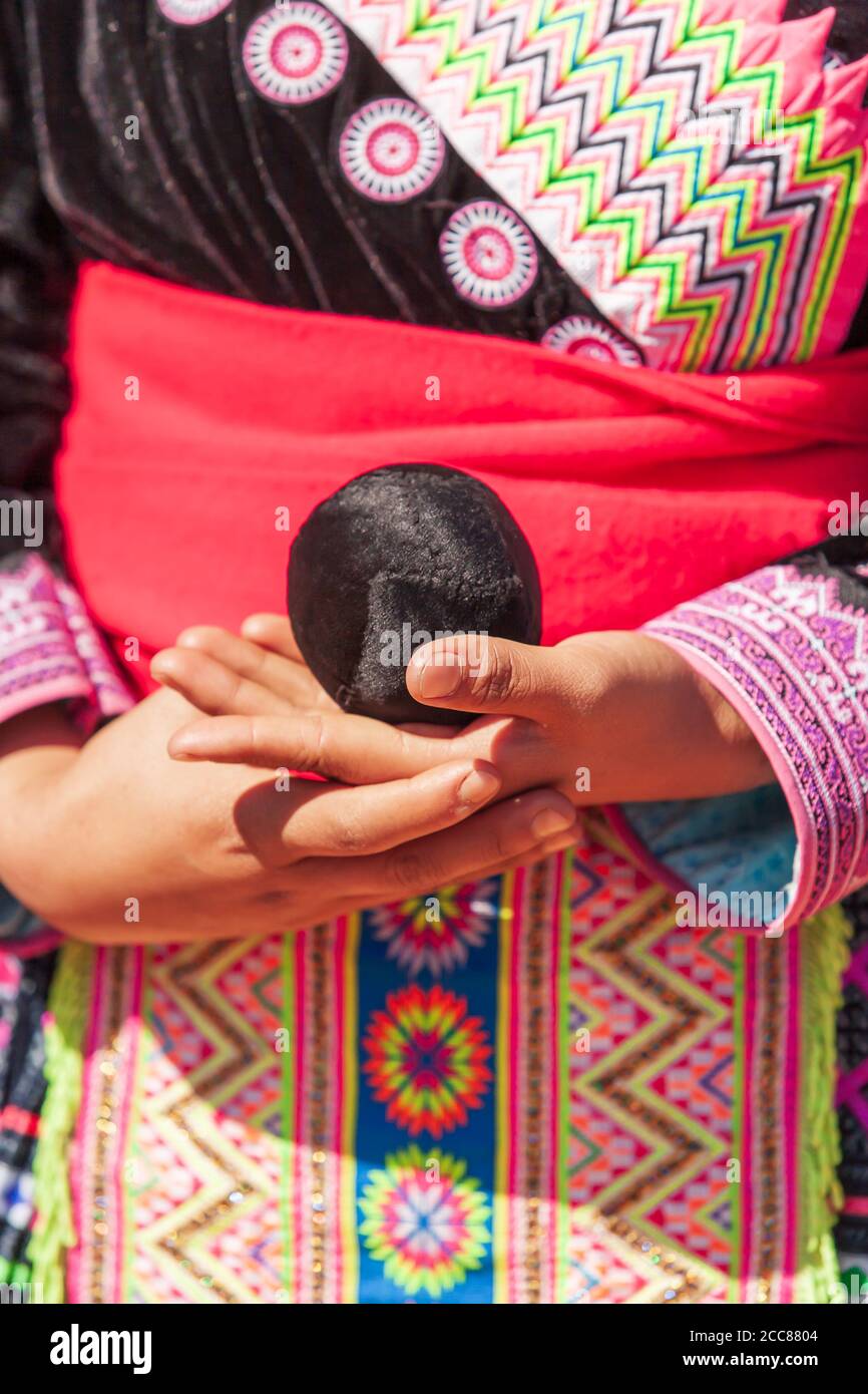 Gros plan sur les mains de la jeune fille tribale de Hmong tenant une corde de coton tissée tout en jouant à un match de jet de balle dans la célébration du nouvel an de Hmong en Thaïlande. Banque D'Images