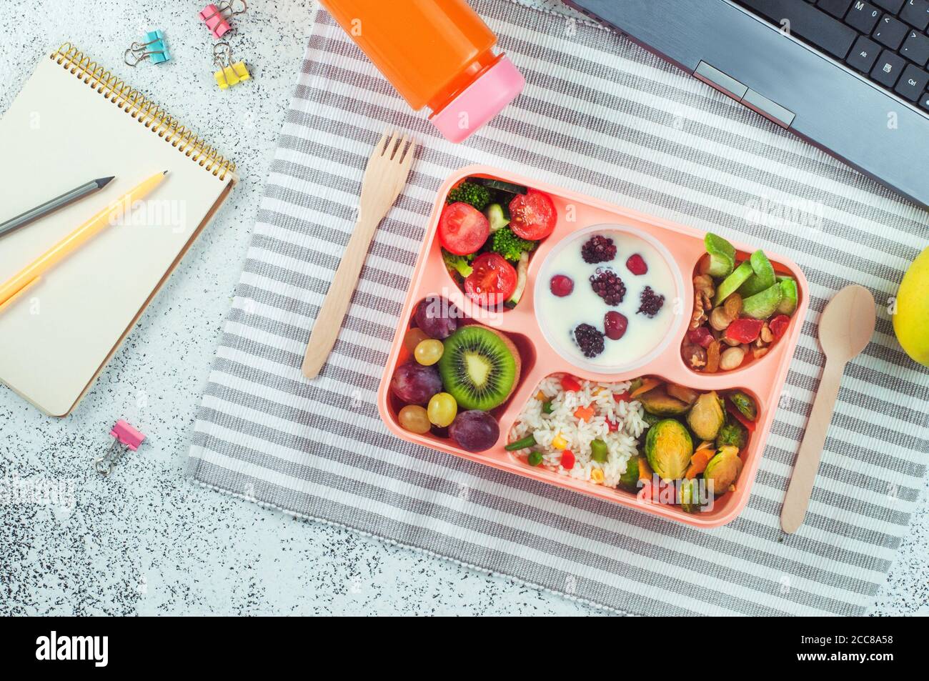 Panier repas avec salade de légumes, baies au yougurt, fruits et riz sur table de bureau Banque D'Images