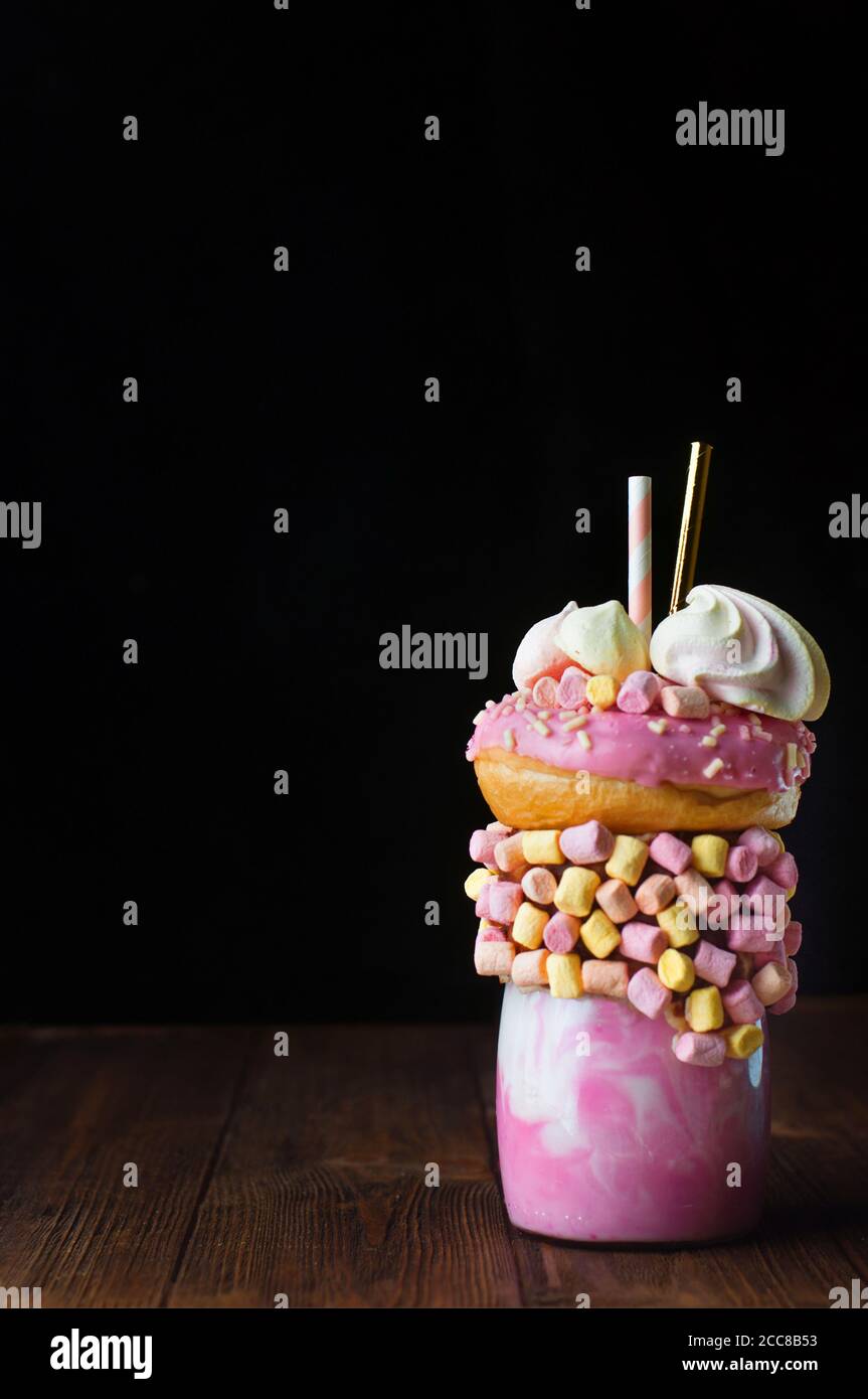 Shake au freak aux framboises sur une table en bois rustique sur fond noir Banque D'Images