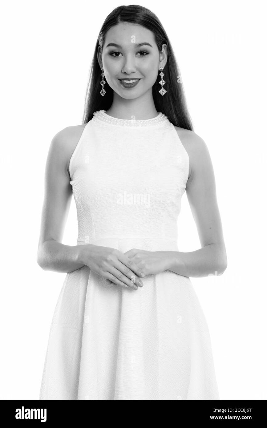 Studio shot of young happy Asian woman smiling with hands together Banque D'Images