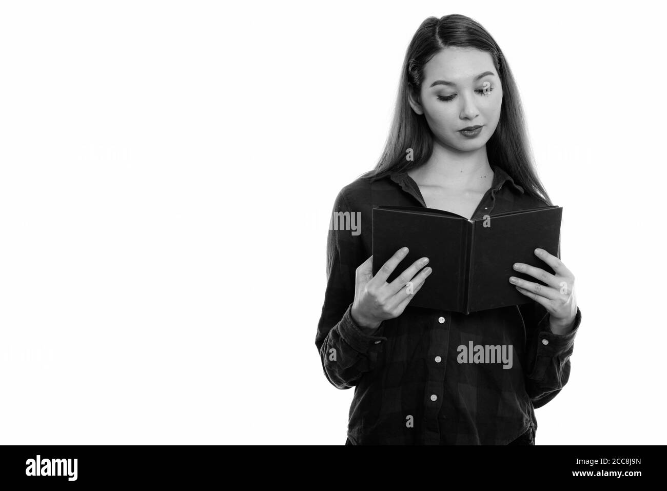 Studio shot of young beautiful Asian Woman Reading book Banque D'Images