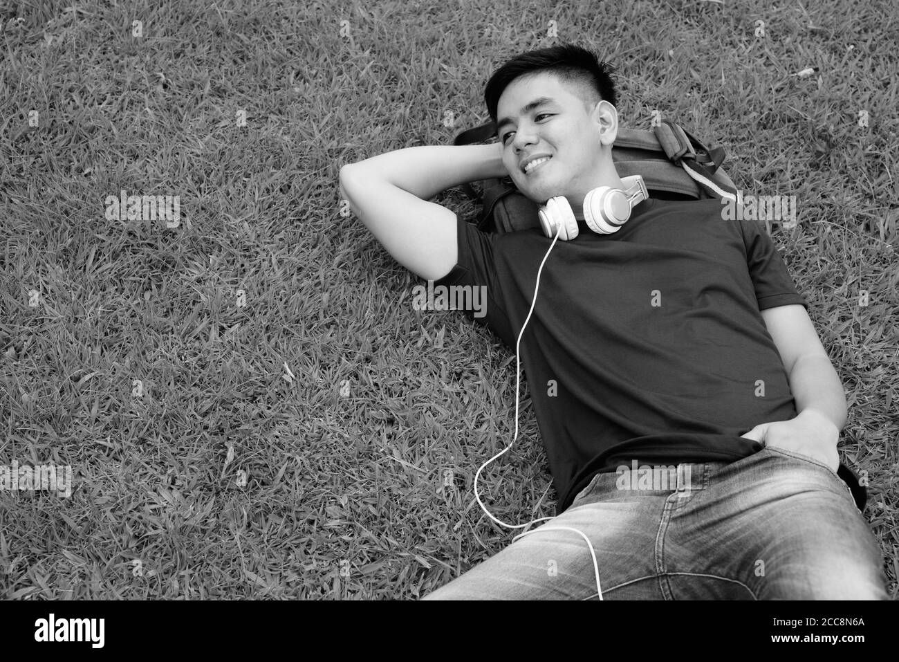 Beau jeune homme asiatique se détendre au parc Banque D'Images