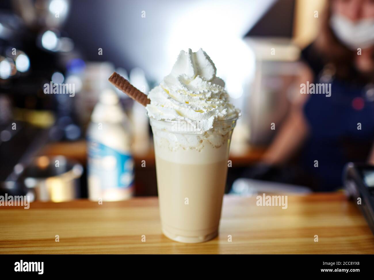 Barista prépare des frittes - café latte glacé au caramel et au sirop de chocolat et à la crème fouettée. Image floue, mise au point sélective Banque D'Images