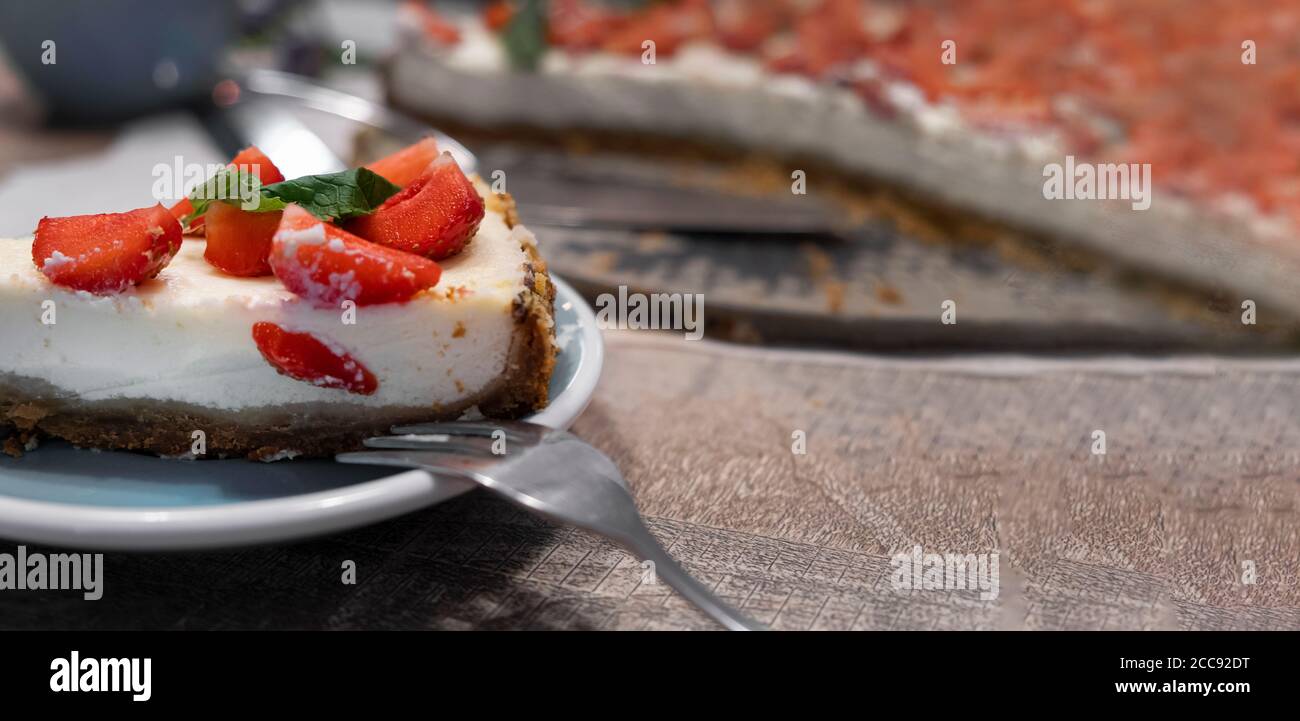 Tranche de cheesecake avec fraises et menthe. Mise au point sélective, gros plan Banque D'Images