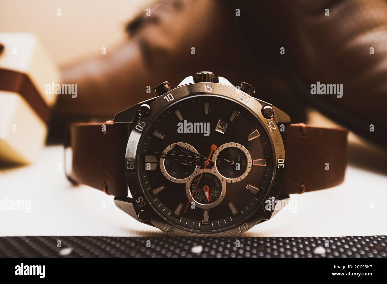 Montre en cuir marron Mans avec chaussures en arrière-plan Banque D'Images