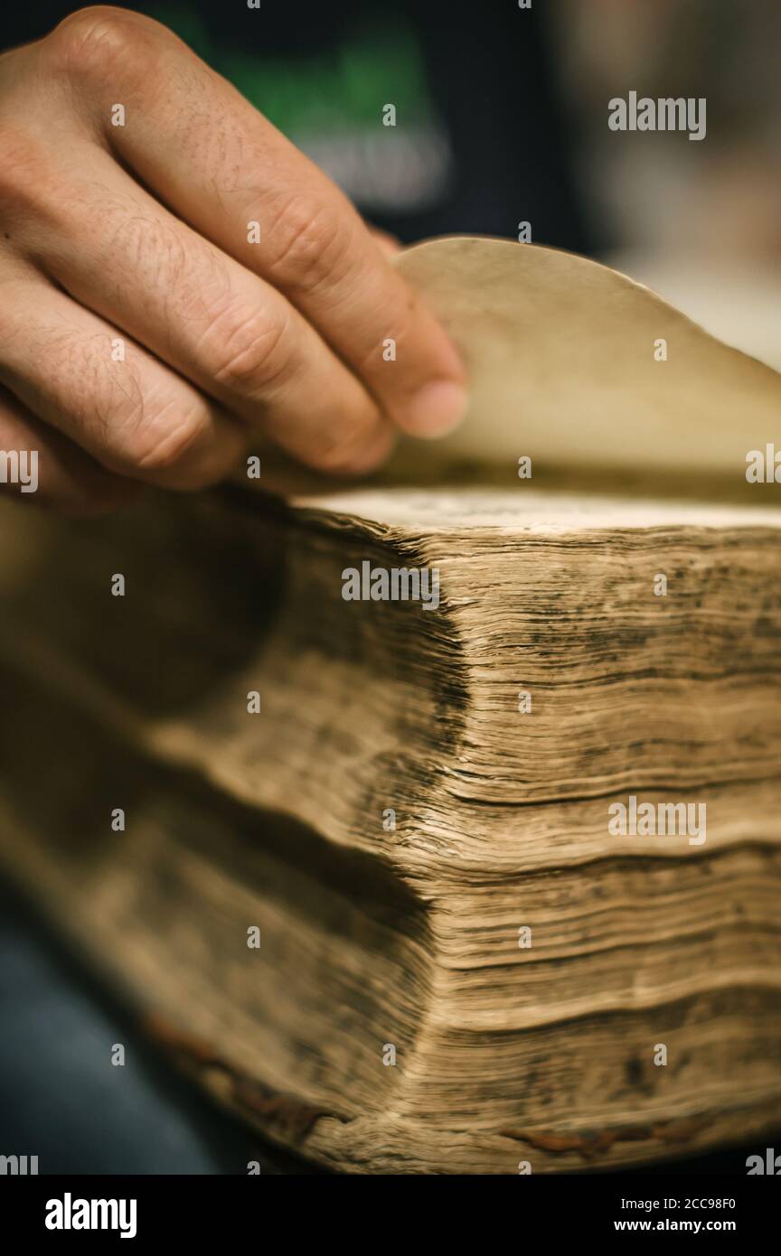 Curieux homme lisant un vieux livre dans sa bibliothèque à la maison. Style rétro Banque D'Images