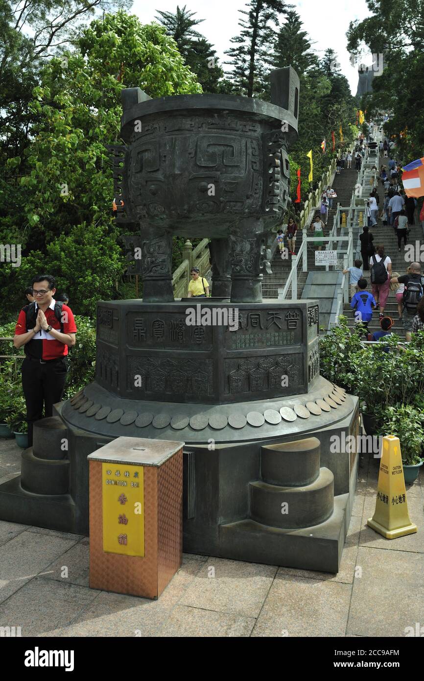 Boîte de donation et urne massive en laiton, au pied des 268 marches de la statue du Bouddha Tian (Grand Bouddha), Ngong Ping, île Lantau, Hong Kong, Chine Banque D'Images