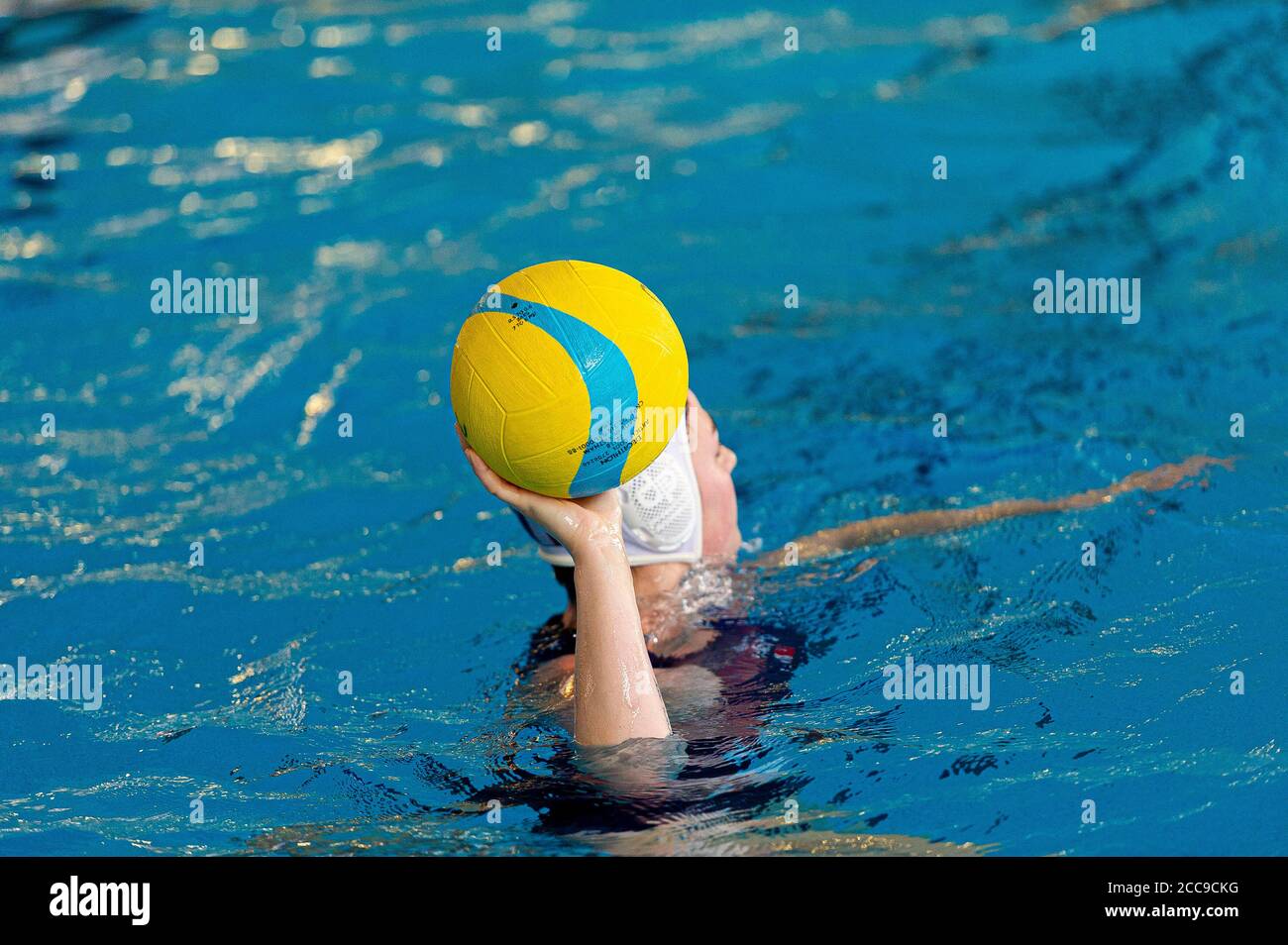 Polo d'eau Mikasa jaune, bleu et rose entre les mains d'un athlète Banque D'Images