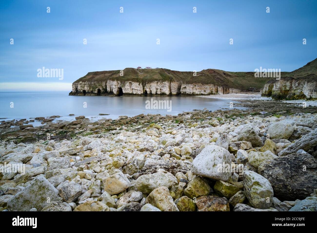 Crique pittoresque, plage rocheuse, hautes falaises escarpées de craie, mer calme, ciel bleu en soirée d'été - Thornwick Bay, Flamborough, East Yorkshire Coast, Angleterre, Royaume-Uni. Banque D'Images
