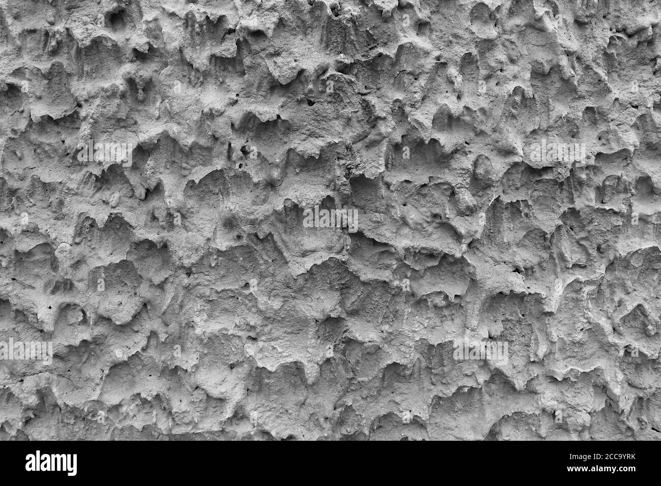 La surface du mur de ciment le rend rugueux. C'est une texture inhabituelle et vient en noir et blanc. Banque D'Images