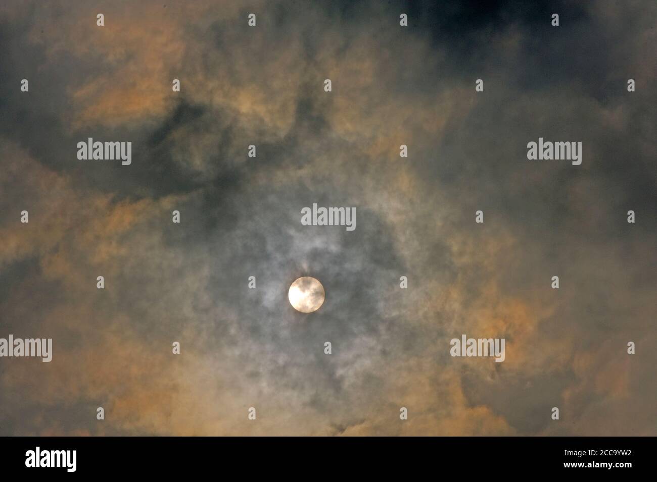 LE SOLEIL DERRIÈRE LES NUAGES ÉPAIS Banque D'Images