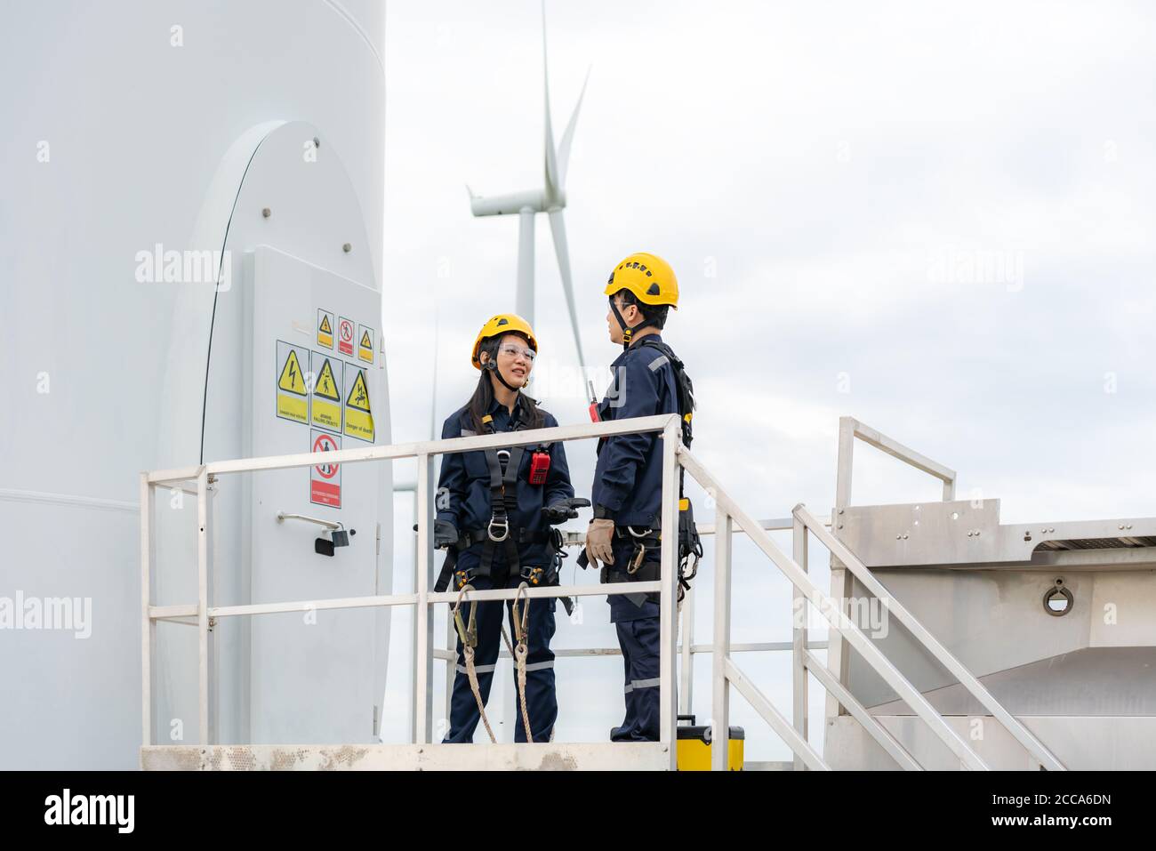 Homme et femme asiatiques ingénieurs d'inspection préparant et faisant le contrôle d'avancement d'une éolienne avec sécurité dans un parc éolien en Thaïlande. Banque D'Images