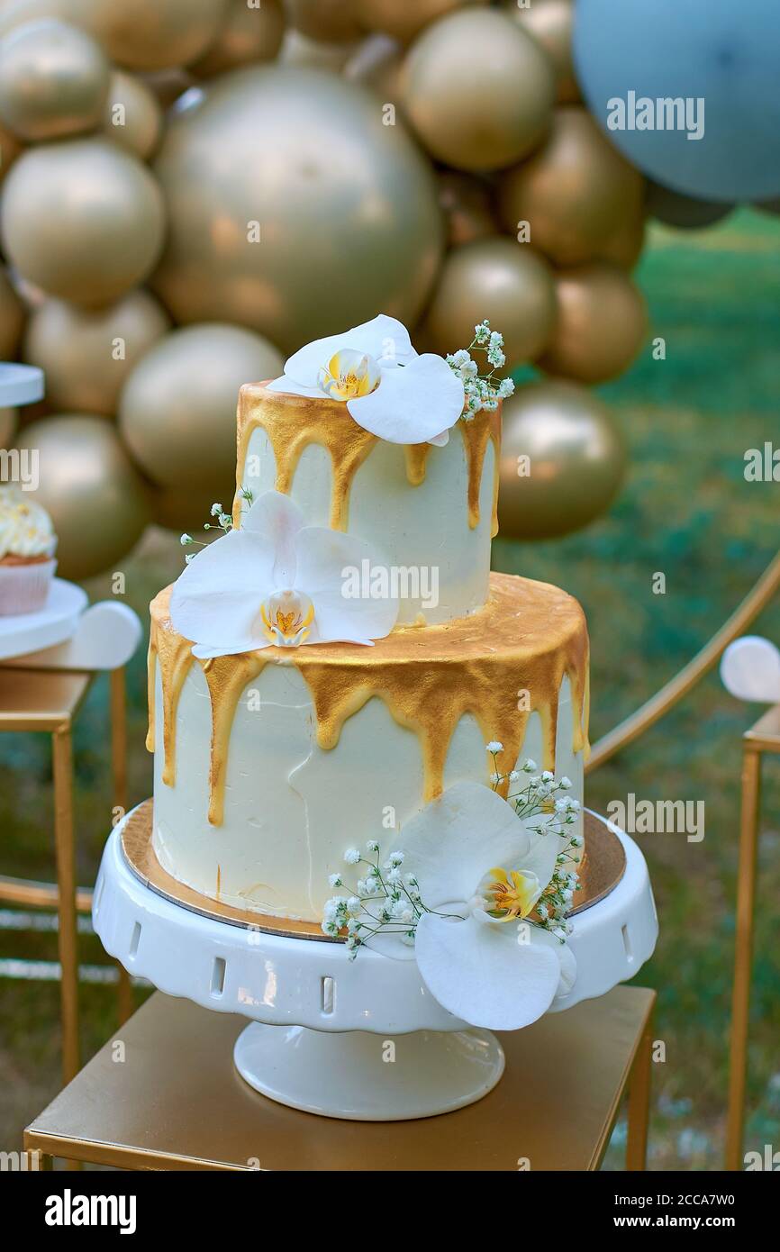 Un Gateau De Mariage De Deux Etages Decore De Fleurs D Orchedea Decoration De Mariage Dans Des Tons Or Decor De Ballons Photo Stock Alamy