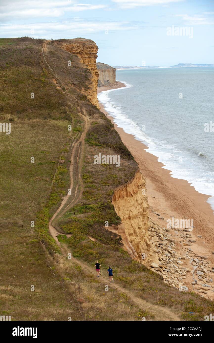 Deux coureurs près de Burton Freshwater Bay le long du South West Coast Path, sur la côte jurassique, Dorset, Angleterre, Royaume-Uni Banque D'Images