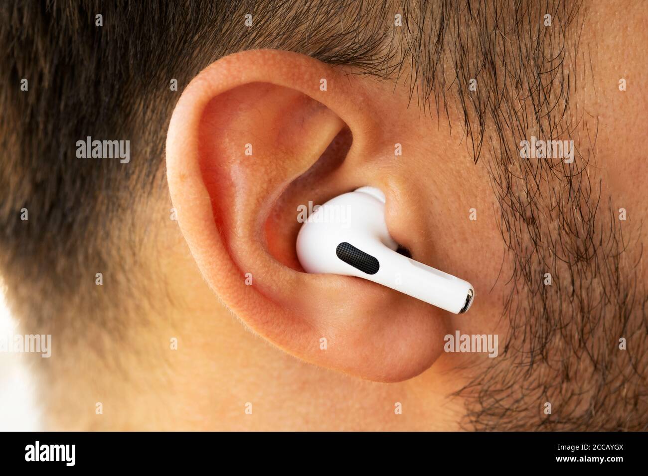 Izmir, Turquie - 7 août 2020 : gros plan d'Airpodes aux pommes blancs sur l'oreille d'un homme. Banque D'Images