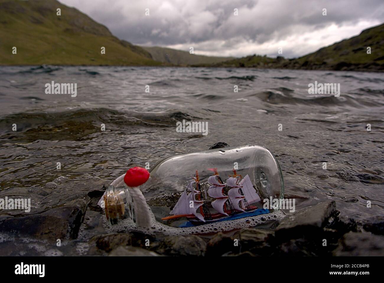 Un petit bateau en bouteille dans un lac de montagne britannique Banque D'Images