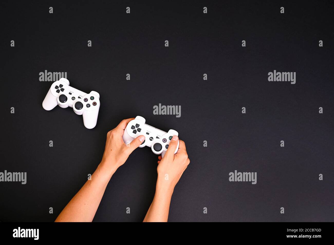 Concours de jeux informatiques. Concept de jeu. Joysticks blancs sur fond noir. Manette de jeu. Les mains dans le cadre jouent sur une console d'ordinateur. Haute qualité . Copier l'espace . Ci-dessus Banque D'Images