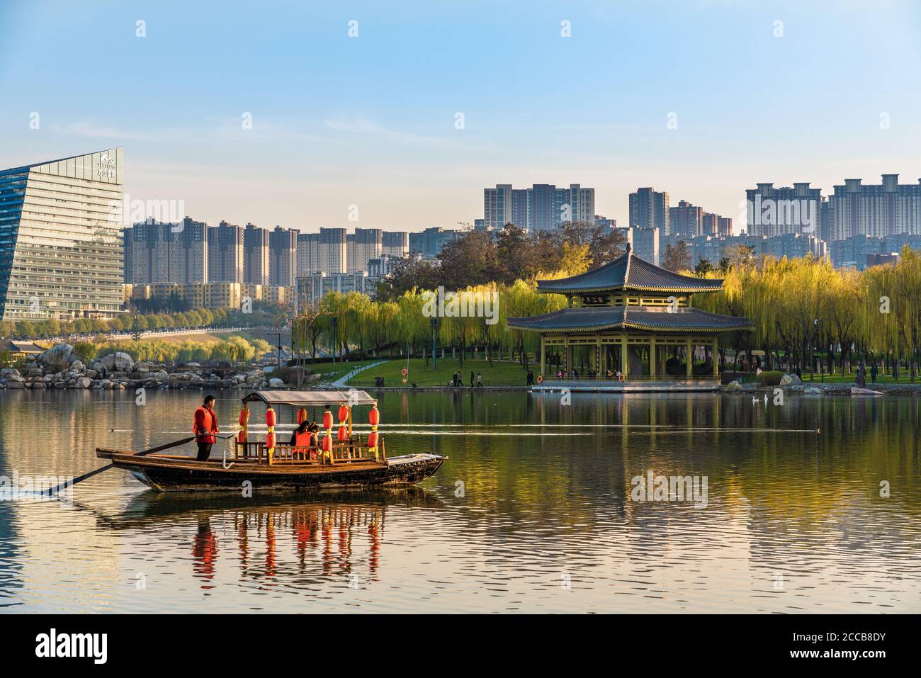 Vue sur le lac avec un bateau chinois traditionnel sur l'eau au parc des reliques de Qujiangchi à Xian, en Chine Banque D'Images