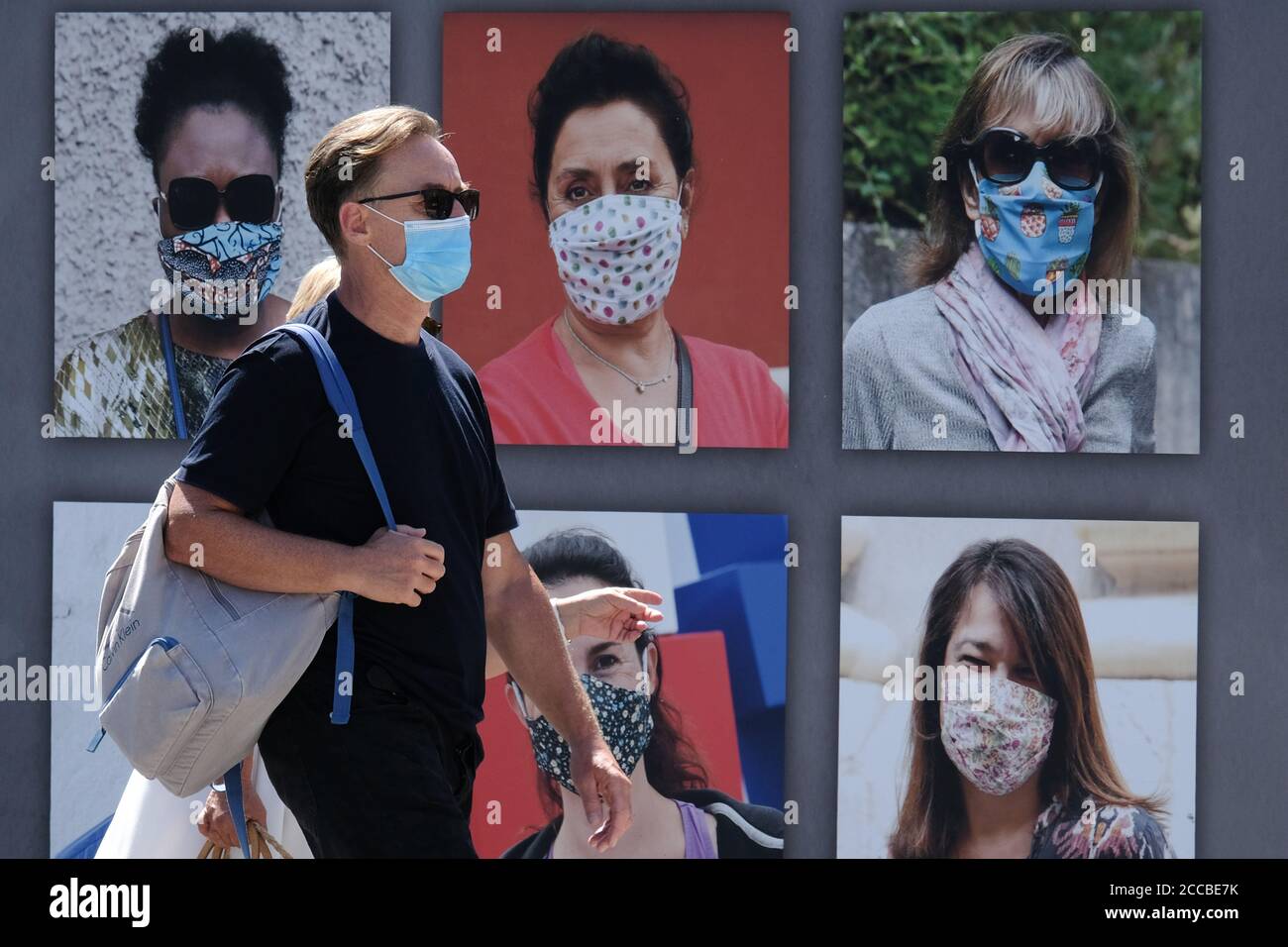 Nice, France. 20 août 2020. Un homme portant un masque marche à côté d'un masque portant des affiches à Nice, dans le sud de la France, le 20 août 2020. Au jeudi, la France a enregistré 4,771 nouveaux cas de coronavirus au cours des 24 dernières heures, la plus forte augmentation quotidienne depuis le début d'avril. Depuis l'éclosion du coronavirus, un total de 229,814 personnes ont attrapé la maladie respiratoire, alors que le nombre de grappes étudiées avait augmenté de 33 à 266 par rapport à mercredi, ont montré les données du ministère de la Santé. Credit: Serge Haouzi/Xinhua/Alay Live News Banque D'Images