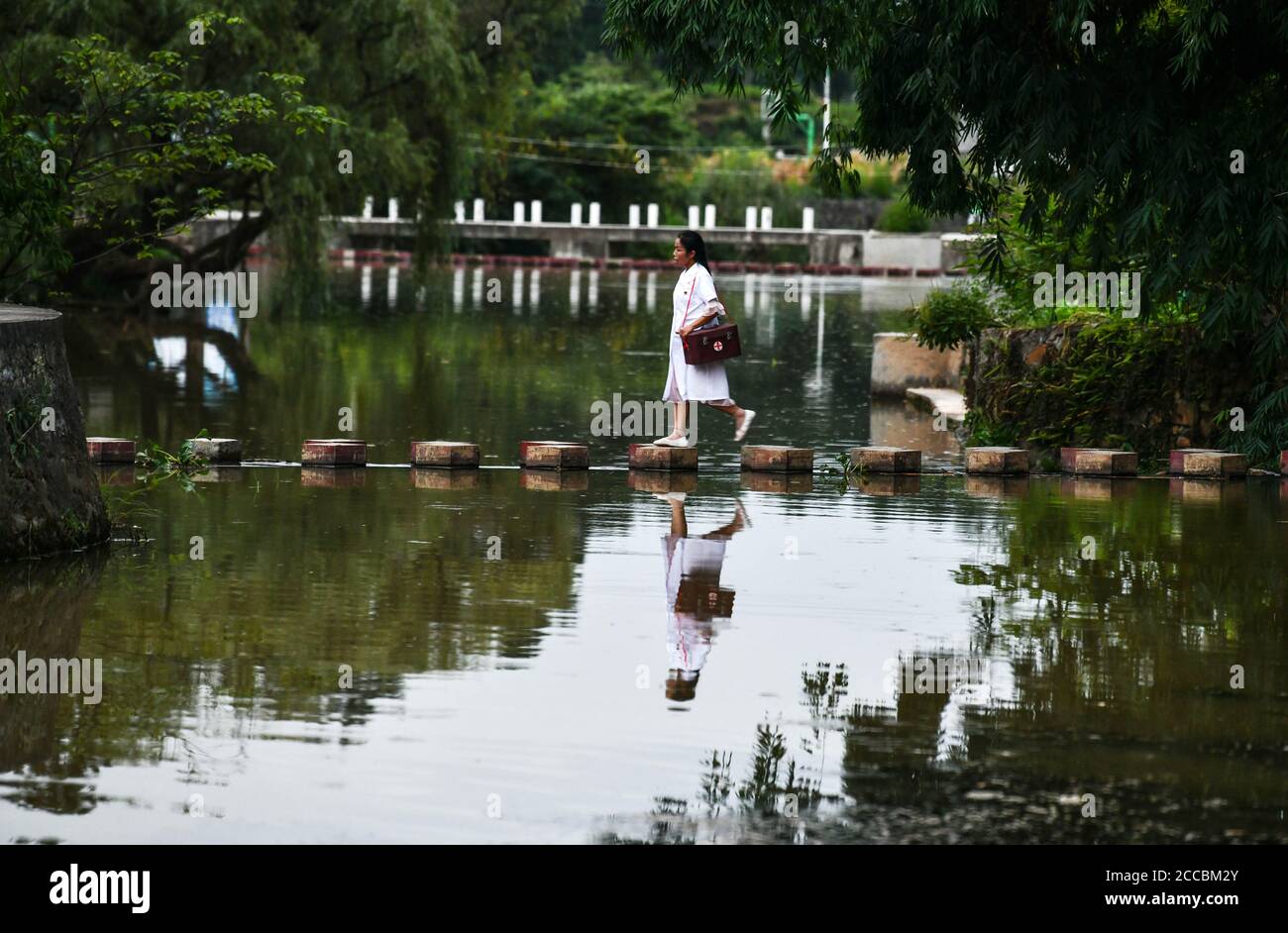 (200821) -- LONGLI, le 21 août 2020 (Xinhua) -- Luo Mu est sur le point de rendre visite à une patiente du village de Cuiwei dans le comté de Longli, préfecture autonome de Qiannan Buyi-Miao, province de Guizhou, dans le sud-ouest de la Chine, le 18 août 2020. Luo Mu, 49 ans, médecin du groupe ethnique Buyi, travaille dans le village de Cuiwei, dans le comté de Longli. Diplômée d'une école de médecine en 2004, elle est rentrée dans le village servant de médaillé. Elle a converti son salon en une clinique avec l'équipement médical qu'elle avait acheté, pour traiter les patients du village. En 2007, Luo a été employé dans une clinique nouvellement fondée dans le village avec un Banque D'Images