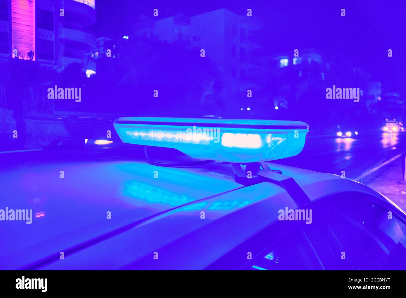 Voiture de police des lumières clignotantes dans la nuit focus sélectif. Banque D'Images