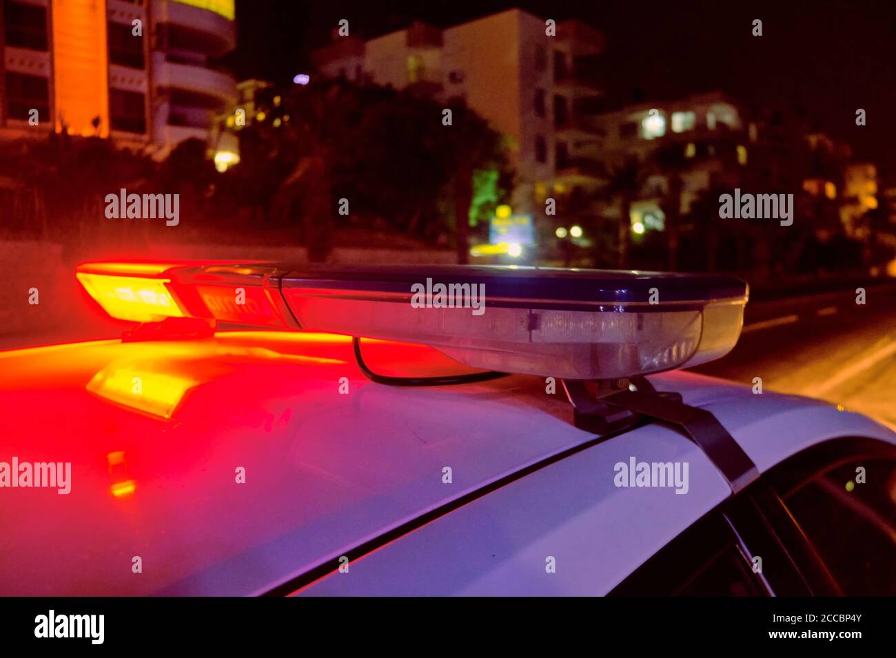 Voiture de police des lumières clignotantes dans la nuit focus sélectif. Banque D'Images