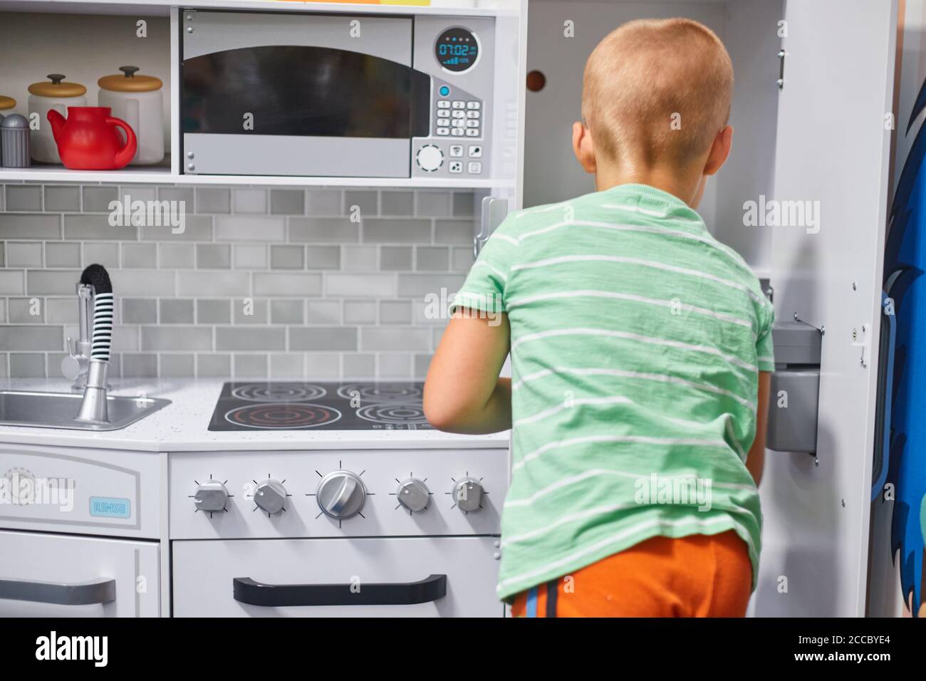 petit garçon jouant dans la cuisine des enfants Banque D'Images