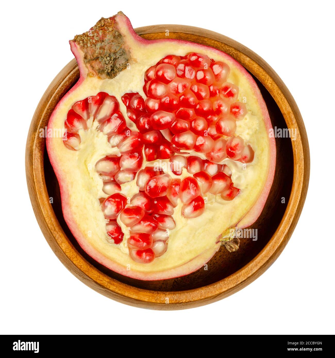 Moitié grenade dans un bol en bois. Fruits ouverts en deux parties, Punica granatum, avec des grappes de graines rouges à pourpres, faites de la sarcotesta, un pelage charnel. Banque D'Images