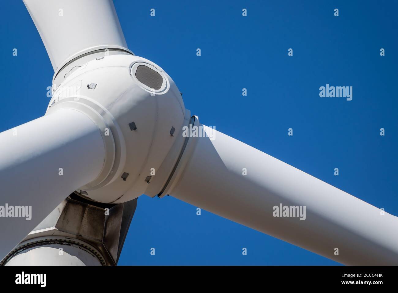 Le rotor de la tête de l'éolienne se ferme sur fond bleu ciel Banque D'Images