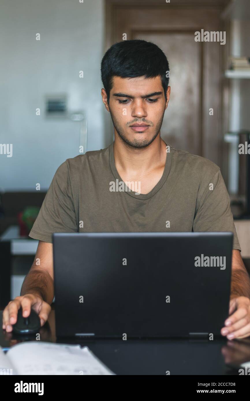 Cliché vertical d'un jeune homme du Caucase étudiant dans son chambre - concept d'étude à la maison Banque D'Images