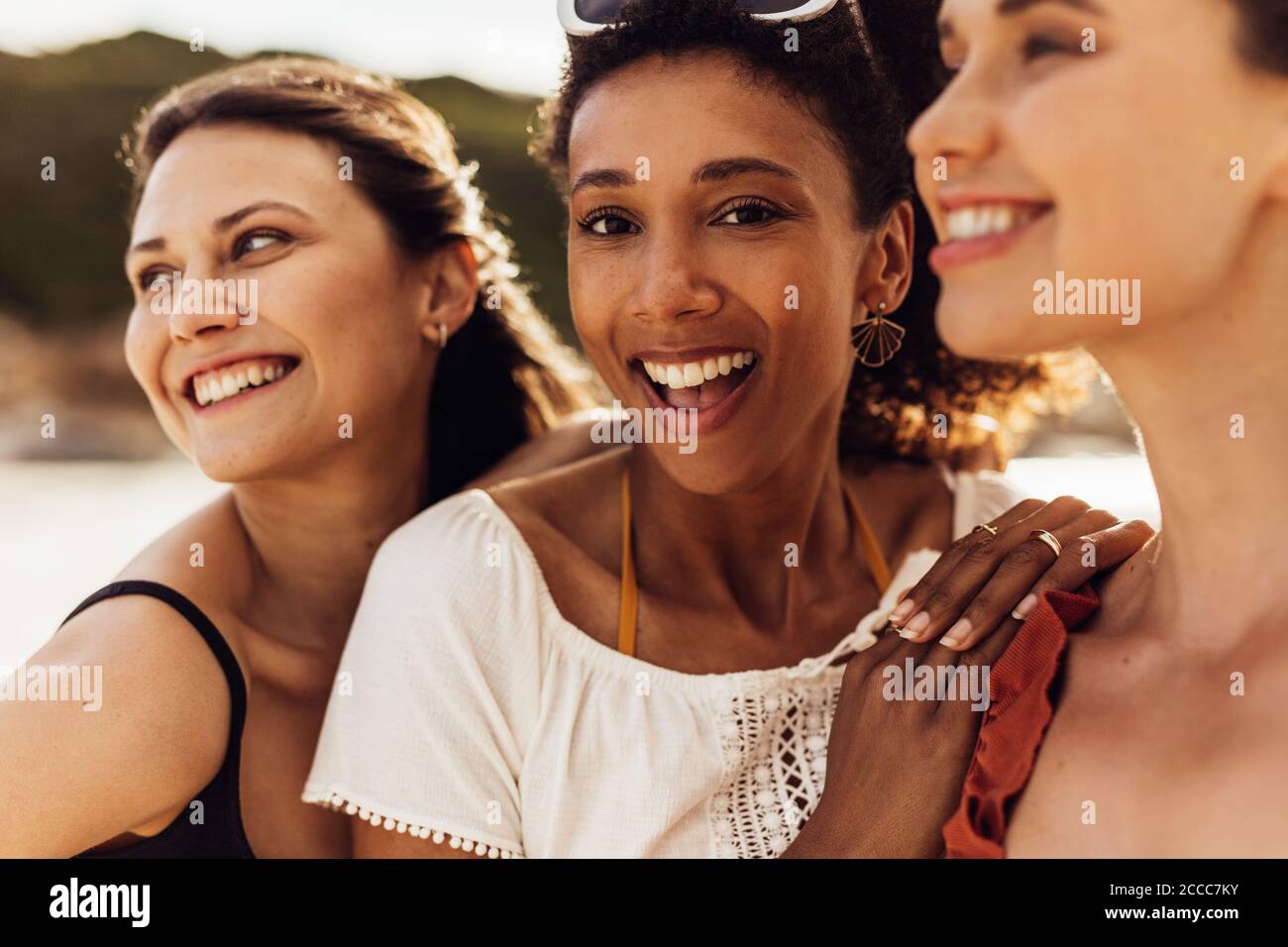 Gros plan de femmes gaies debout à l'extérieur. Des femmes amis multiethniques appréciant des vacances. Banque D'Images
