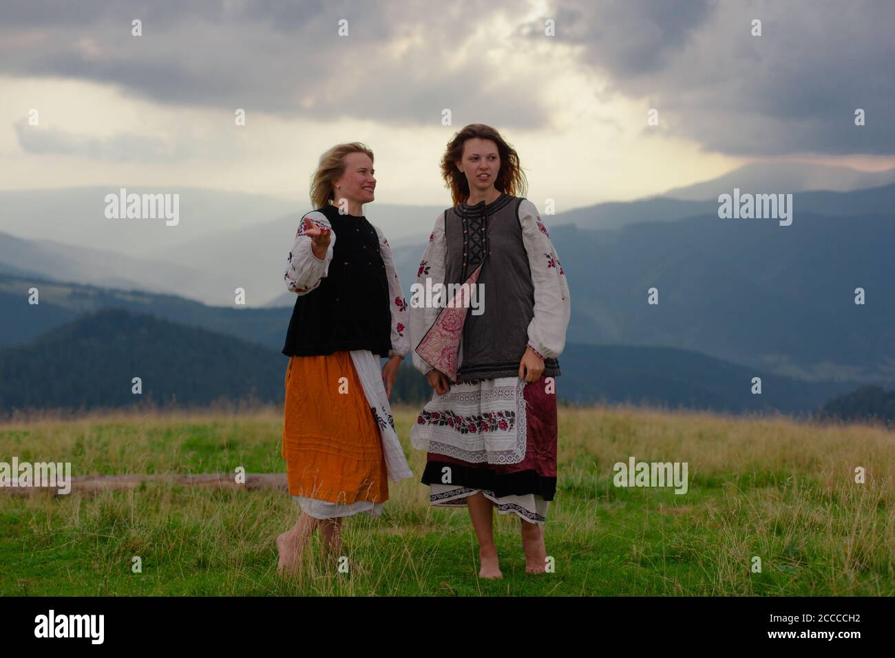 Deux fille gaie émotive dans des vêtements de broderie ukrainienne haut dans les carpathian montagnes en été Banque D'Images