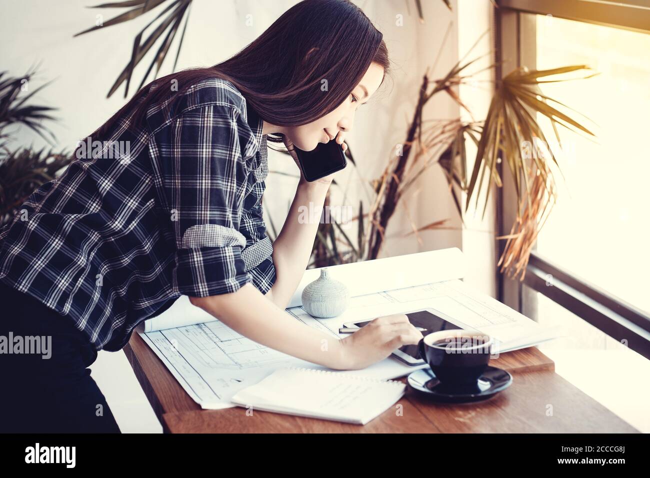 Concept d'espace de travail d'architecte, Architectes femme asiatique travaillant avec des plans de construction de Blueprints , smartphone et tablette dans le bureau, style vintage. B Banque D'Images