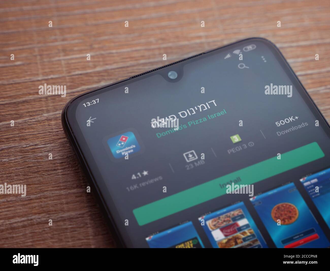 LOD, Israël - 8 juillet 2020 : page de lecture de l'application Domino's Pizza Israel sur l'écran d'un smartphone mobile noir sur fond de bois. Vue de dessus à plat Banque D'Images