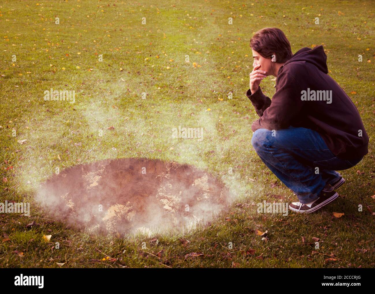 Homme contemplant un trou géant avec de la fumée qui sort il Banque D'Images