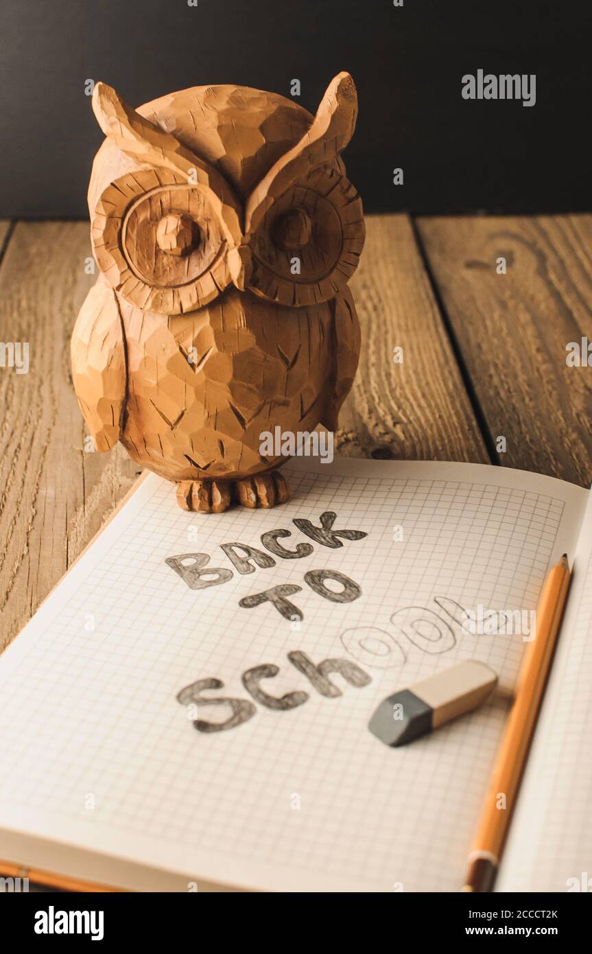 Retour à l'école, la notion de parent. Owl sur une table en bois. L'inscription sur la craie de couleur ardoise. Fournitures scolaires, rustique. Banque D'Images