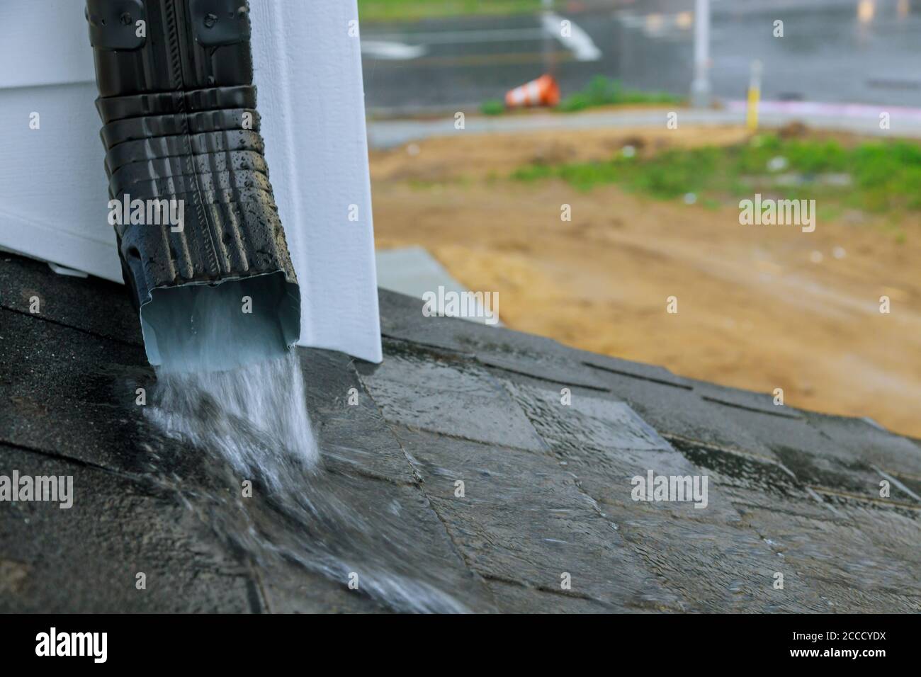 Une gouttière de travail sur une eau de pluie s'écoulant de l'eau coule sur le toit pendant la saison des pluies. Banque D'Images