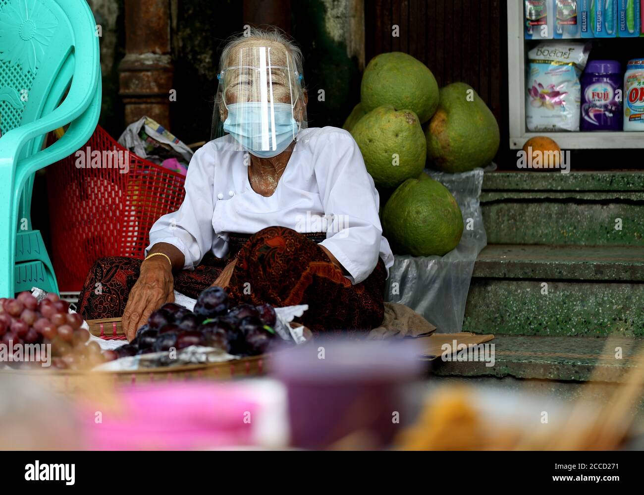 Yangon, Myanmar. 21 août 2020. Un vendeur âgé portant un masque facial et un masque facial est vu vendre des fruits au bord de la route à Yangon, Myanmar, le 21 août 2020. Le Myanmar a signalé vendredi 10 autres cas de COVID-19 transmis localement, selon un communiqué du ministère de la Santé et des Sports. Credit: U Aung/Xinhua/Alamy Live News Banque D'Images