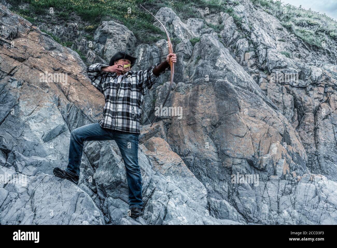 Chasseur de loisirs dans le chapeau de tir à l'arc de longue. Tir à l'arc naturel. Banque D'Images