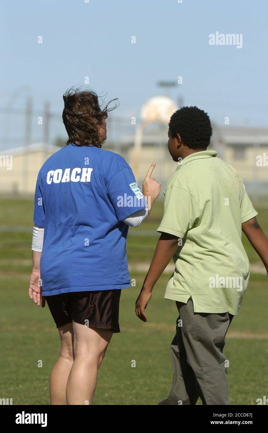 Austin, Texas États-Unis, 25 avril 2007: Une entraîneure féminine de l'équipe Ultimate de l'école moyenne parle avec un joueur noir pendant la pratique. ©Bob Daemmrich Banque D'Images